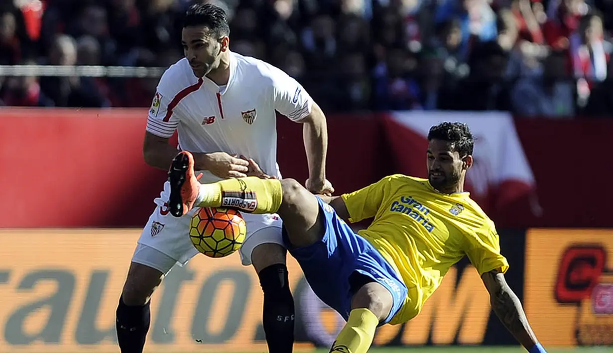 Bek Sevilla, Adil Rami, berebut bola dengan penyerang Las Palmas, Willian Jose, pada laga La Liga di Stadion Roman Sanchez Pizjuan, Spanyol, Minggu (14/2/2016). Sevilla berhasil menaklukan Las Palmas 2-0. (AFP/Cristina Quicler)
