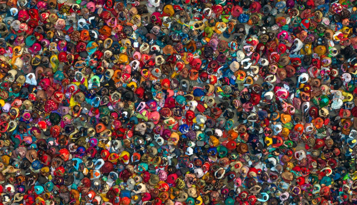 Umat Hindu mendengarkan seorang pemimpin agama saat Festival Magh Mela di Sangam, pertemuan Sungai Gangga - Sungai Yamuna, Prayagraj, Uttar Pradesh, India, 31 Januari 2023. Ratusan ribu peziarah Hindu diperkirakan akan berenang dalam pertemuan tersebut, berharap bisa menghapus dosa selama festival sebulan penuh. (AP Photo/Rajesh Kumar Singh)