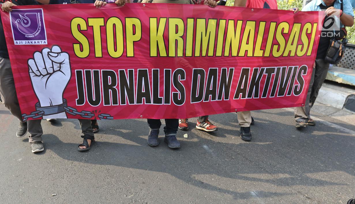 Sejumlah Jurnalis yang tergabung dalam Aliansi Jurnalis Independen (AJI) membentangkan spanduk dan poster saat menggelar aksi menuntut pencabutan status tersangka Dandhy Dwi Laksono pada Car Free Day di Kawasan Bundaran HI, Jakarta, Minggu (29/9/2019).