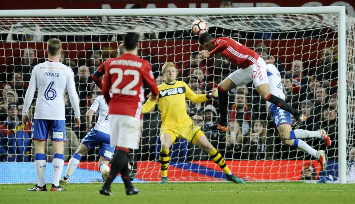 Aksi pemain Manchester United, Chris Smalling (kanan) mencetak gol ke gawang Wigan Athletic pada putaran keempat Piala FA di Old Trafford, Manchester,  (29/1/2017). Manchester United menang 4-0. (AP/Rui Vieira)
