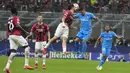 Penyerang Atletico Madrid, Luis Suarez berebut bola udara dengan bek AC Milan, Davide Calabria pada pertandingan grup B Liga Champions di stadion San Siro di Milan, Italia, Rabu (29/9/2021). Atletico Madrid menang tipis atas AC Milan 2-1.  (AP Foto/Antonio Calanni)