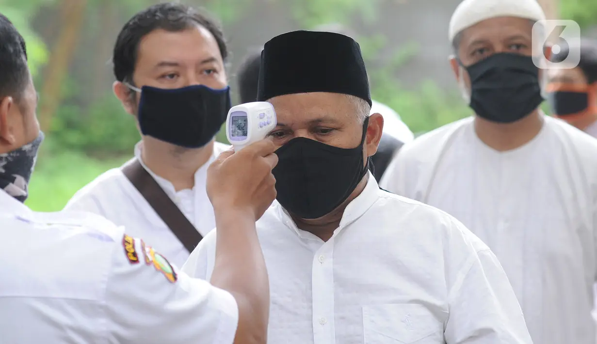 Petugas mengecek suhu tubuh seorang pria sebelum memasuki Masjid Raya Cinere untuk salat Jumat berjemaah di Depok, Jumat (5/6/2020). Umat muslim di sejumlah wilayah Jabodetabek menunaikan salat Jumat perdana setelah dua bulan kegiatan ibadah di masjid ditiadakan. (merdeka.com/Arie Basuki)