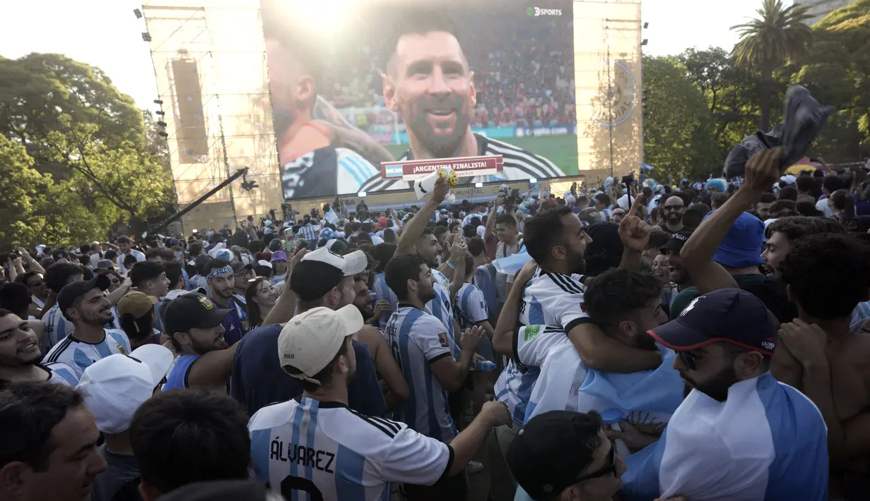 Para penggemar Argentina merayakan kemenangan atas Kroasia pada akhir pertandingan semifinal Piala Dunia  2022 Qatar setelah menontonnya di layar, di mana gambar langsung Lionel Messi ditampilkan, di lingkungan Palermo di Buenos Aires, Argentina, Rabu (14/12/2022). (AP Photo/Rodrigo Abd)