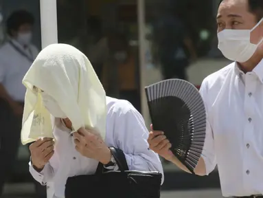 Seorang pria memakai handuk dikepalanya saat berjalan di bawah terik matahari di Tokyo, Selasa (10/8/2021). Menurut biro meteorologi Jepang, cuaca panas panas terus berlanjut di wilayah metropolitan saat suhu naik menjadi 338 derajat Celcius (100,4 derajat Fahrenheit). (AP Photo/Koji Sasahara)