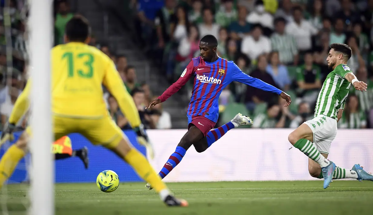 <p>Pemain Barcelona Ousmane Dembele (tengah) beraksi saat melawan Real Betis pada pertandingan sepak bola La Liga Spanyol di Stadion Benito Villamarin, Seville, Spanyol, 7 Mei 2022. Barcelona menang 2-1. (AP Photo/Jose Breton)</p>
