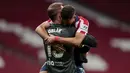 Kiper Atletico Madrid, Jan Oblak (kiri) memeluk bek Renan Lodi usai berakhirnya laga lanjutan Liga Spanyol 2020/2021 pekan ke-36 melawan Real Sociedad di Wanda Metropolitano Stadium, Rabu (12/5/2021). Atletico menang 2-1 atas Sociedad. (AP/Bernat Armangue)