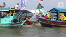 Sejumlah nelayan bersiap untuk melarung replika kapal berisi sesaji di Pantai Tarumajaya, Kabupaten Bekasi, Jawa Barat, Jumat (28/1/2022). Ritual ini diikuti sebanyak 40 kapal nelayan dari enam Muara. (Liputan6.com/Herman Zakharia)