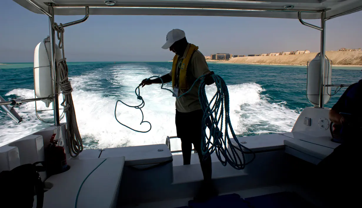 Seorang pelaut mengumpulkan tali jangkarnya setelah menyelam di Laut Merah, dekat King Abdullah Economic City, Arab Saudi. Pesona keindahan Laut Merah memikat pengunjung dari seluruh dunia. (AP Photo/Amr Nabil)