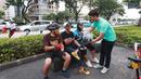Seorang anggota komunitas Centennialz membagikan pita hitam kepada warga dalam Aksi Duka 1 Juta Pita Hitam untuk Timnas Indonesia U-20 dan Piala Dunia U-20 di trotoar FX Sudirman, Jakarta, Jumat (31/3/2023). (Bola.com/M Iqbal Ichsan)