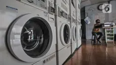 Pekerja duduk di bangku kasir saat menunggu pelanggan di Jaksa Clean Coin Laundry, Jalan Jaksa, Jakarta, Kamis (1/4/2021). Akibat pandemi Covid-19, jasa cuci pakaian mandiri atau self service mengalami sepi pelanggan mencapai 50 persen. (merdeka.com/Iqbal S Nugroho)