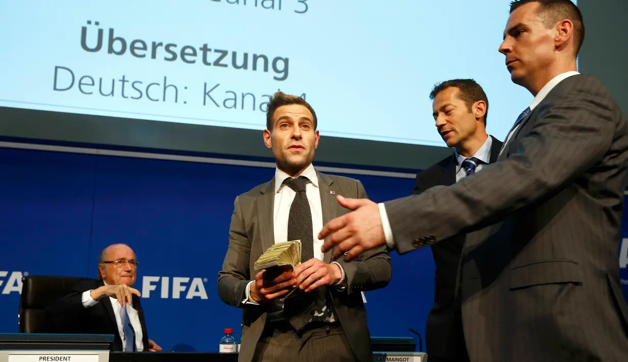 Petugas keamanan mengamankan Lee Nelson saat konferensi pers di markas FIFA di Zurich, Swiss (20/7/2015). ). Kedatangan Nelson membuat jumpa pers tertunda beberapa saat. (REUTERS/Arnd Wiegmann)