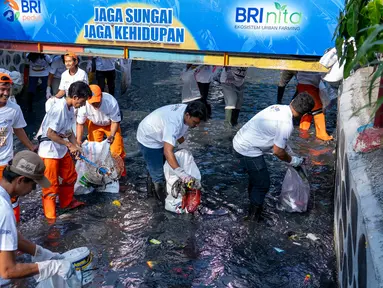 Warga bersih-bersih sampah pada aliran sungai di Lingkungan RW 03, Kelurahan Kampung Bali, Kecamatan Tanah Abang, Jakarta Pusat. Perilaku masyarakat sekitar yang menjaga kebersihan lingkungan tempat tinggal secara bertahap menjadi kebiasaan baik yang diharapkan bisa menjadi kampung percontohan di tengah Kota Jakarta. (Dok. BRI)