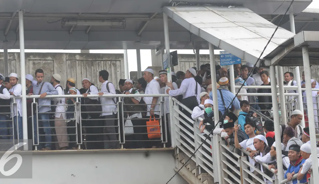 Antrean peserta aksi 212 saat melewati penyeberangan orang (JPO) di kawasan Pasar Baru, Jakarta, Jumat (2/12). Peserta aksi pulang dengan tertib usai melaksanakan Salat Jumat. (Liputan6.com/Helmi Afandi)