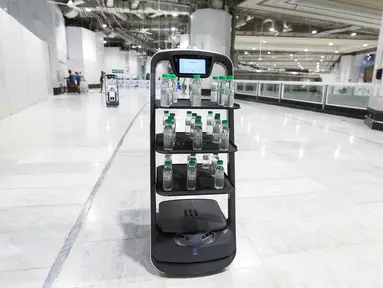 Gambar pada 15 Juni 2021, menunjukkan robot pembawa air Zamzam di sekitar Masjidil Haram di Makkah, Arab Saudi. Ini dilakukan agar para jemaah haji tak berdesakan saat akan minum air suci zamzam dan mengurangi kontak langsung dengan staf sebagai langkah mencegah penyebaran Covid-19. (AFP Photo)