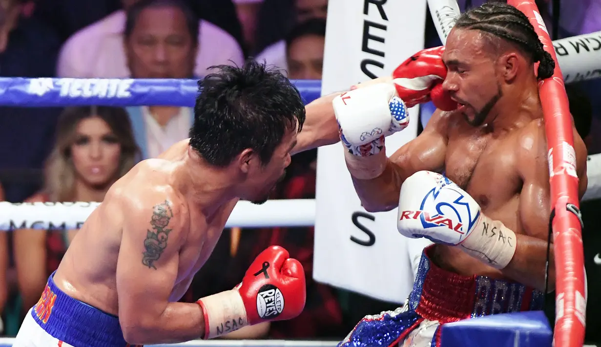 Petinju Manny Pacquiao (kiri) melancarkan pukulan ke arah Keith Thurman dalam pertarungan gelar tinju Super World kelas Welter WBA di MGM Garden Arena, Las Vegas, Sabtu (20/7/2019). Pacquiao merebut sabuk juara WBA Super dengan skor 115-112, 115-112, dan 113-114. (Ethan Miller/GETTY IMAGES/AFP)