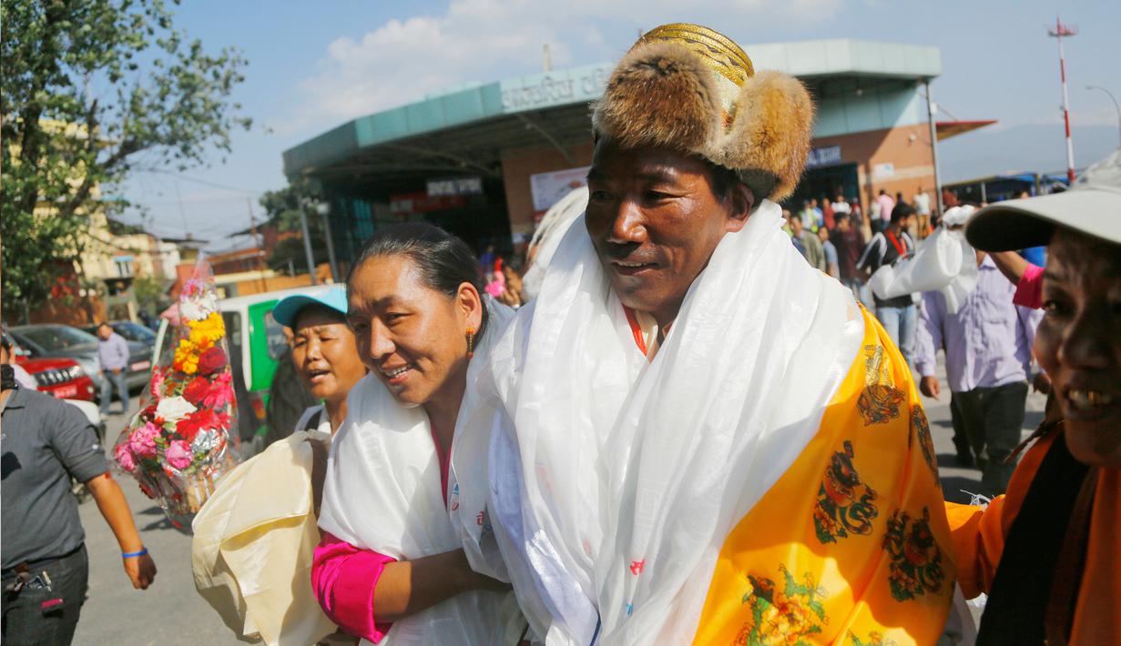 Pendaki asal Nepal, Kami Rita Sherpa disambut oleh istrinya di bandara di Kathmandu, Nepal, Sabtu (25/5/2019). Kami merasa masih mampu untuk melakukan pendakian ke Gunung Everest. (AP Photo/Niranjan Shrestha)