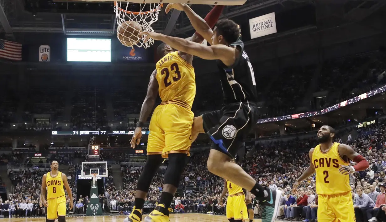 Pemain Milwaukee Bucks, Malcolm Brogdon melakukan dunks melewati hadangan pemain Cleveland Cavaliers, LeBron James (23) pada laga NBA di BMO Harris Bradley Center, (20/12/2016). Cavs menang 114-108.  (AP/Morry Gash)
