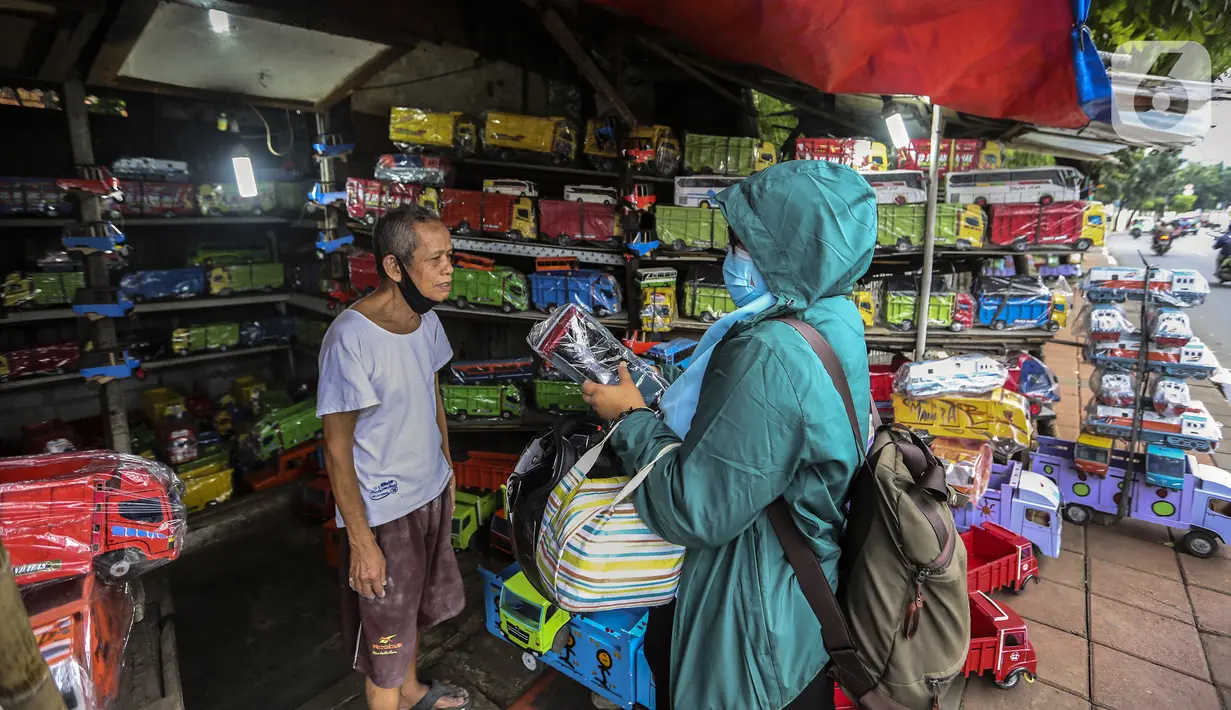Marsyaad atau biasa dipanggil Pak Umar (79) melayani pembeli di toko mainan miliknya di Kalibata, Jakarta, Kamis (25/2/2021). Kendati pandemi COVID-19, Pak Umar yang mulai bisnis bermodal Rp 800 bahkan bisa mengirim mainan anak buatannya ke beberapa wilayah di Jawa. (Liputan6.com/Johan Tallo)