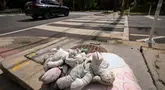 Boneka putih kecil diletakkan di jalan Irving dan 14th, Timur Laut, di Washington, DC, memberikan penghormatan kepada Allie Hart, 5 tahun, yang tertabrak dan meninggal dunia di tempat penyeberangan ini pada tahun 2021. (AP Photo/Mark Schiefelbein)