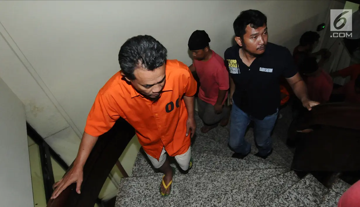 Petugas Dittipid Siber Bareskrim Polri menggiring tersangka kejahatan siber usai rilis di Jakarta, Rabu (21/2). 18 tersangka yang ditahan, 8 dari Jabar, 4 Jakarta, 1 Banten, 1 Bandung, 1 Lampung, 1 Jaktim, dan 2 Sumut. (Liputan6.com/Helmi Fithriansyah)
