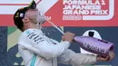 Pembalap Mercedes, Valtteri Bottas menuangkan sampanye untuk dirinya sendiri di atas podium setelah menjuarai balapan Formula 1 (F1) GP Jepang di Sirkuit Suzuka, Minggu (13/10/2019). Bottas menjadi pembalap pertama yang menyentuh garis finis usai melakoni lomba 53 putaran. (AP/Toru Takahashi)