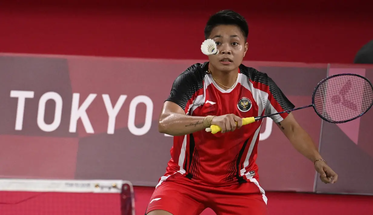 Pebulu tangkis Indonesia Apriyani Rahayu melakukan pukulan pada pertandingan pertama Grup A bulu tangkis ganda putri melawan Malaysia di Musashino Forest Sport Plaza, Sabtu (24/7/2021). Greysia Polii / Apriyani mengalahkan Chow Mei Kuan / Lee Meng Yean dengan skor 21-17. (Alexander NEMENOV/AFP)