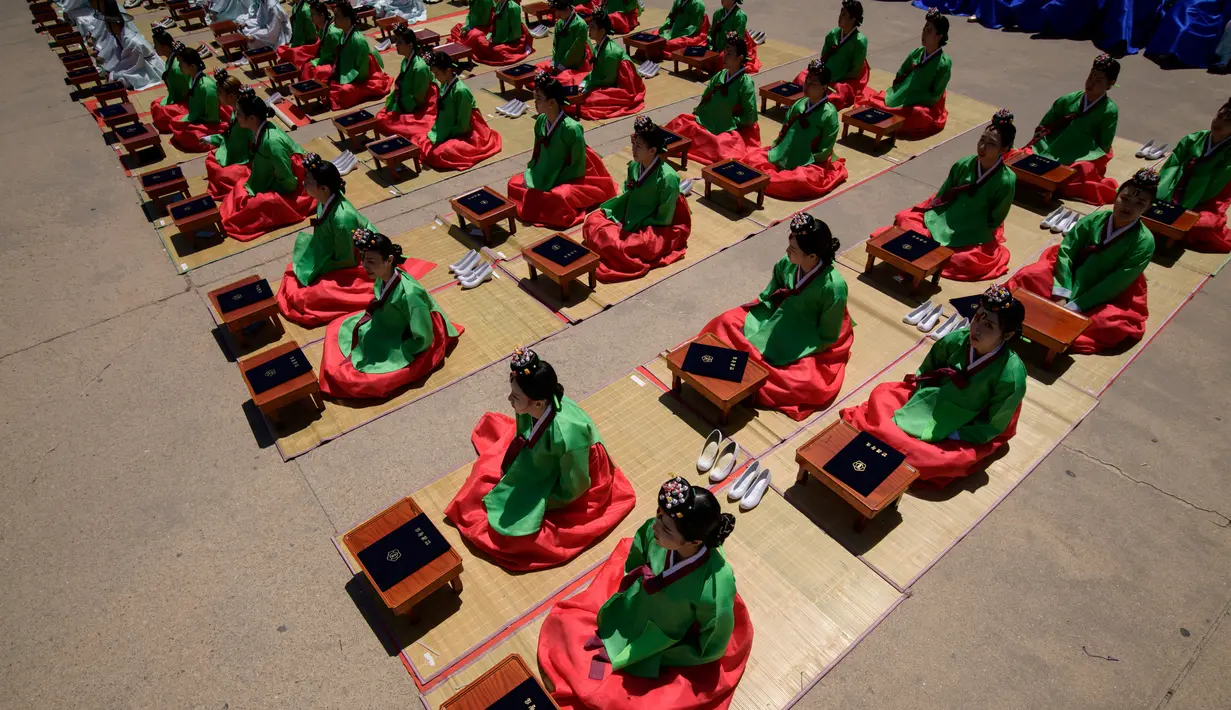 Para wanita muda mengikuti ritual upacara “Coming of Age” di Namsan Hanok Village, Seoul, Senin (20/5/2019). Di Korea Selatan, Coming of Age Day atau hari kedewasaan dirayakan secara nasional setiap tahun pada hari Senin ketiga di bulan Mei. (Ed JONES/AFP)