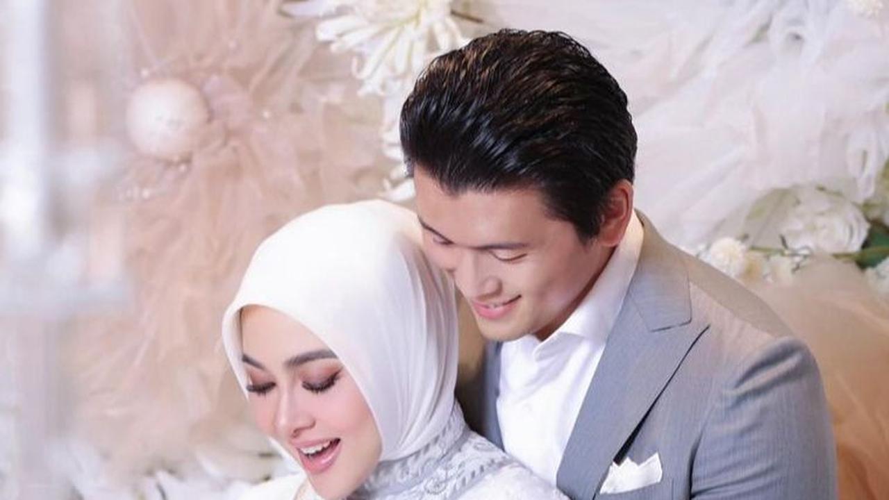 Sang suami, Reino Barack pun juga tampak gagah dengan pakaian jas abu-abu serta kemeja putih yang senada dengan pakaian Syahrini di acara tersebut.<br>