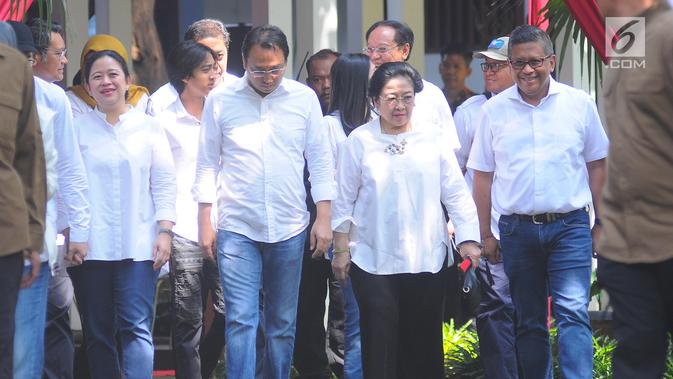 Ketum PDIP yang juga Presiden kelima RI Megawati Soekarnoputri bersama putrinya Puan Maharani (kiri) dan putranya Muhammad Prananda Prabowo (kedua kiri) berjalan dari kediamannya untuk menggunakan hak pilihnya pada Pemilu 2019 di TPS 62, Kebagusan, Jakarta, Rabu (17/4). (Liputan6.com/Angga Yuniar)