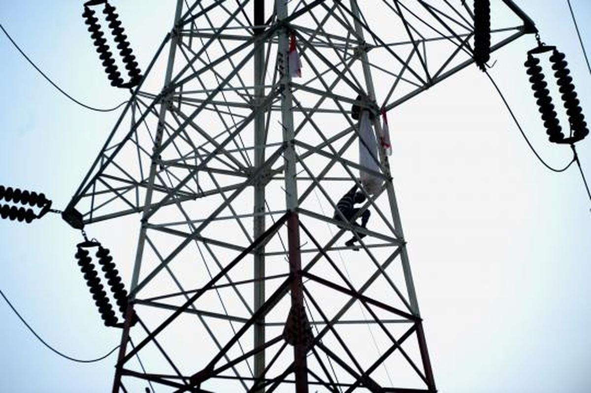 Pria berpakaian pocong di atas tower SUTET