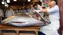 <p>Pekerja jaringan restoran sushi ternama Sushizanmai membuka tuna sirip biru seberat 276 kg yang dibeli perusahaannya di restoran utama mereka di Tokyo, Minggu (5/1/2020). Tuna seharga Rp 24 miliar itu disebut sebagai yang tertinggi kedua dalam rekor lelang ikan di Pasar Toyosu. (Kazuhiro NOGI / AFP)</p>