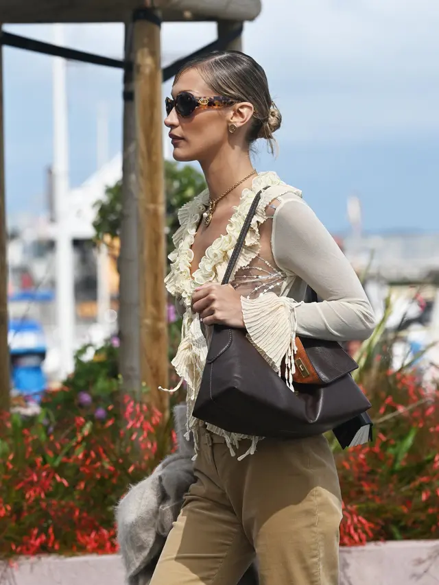 Bella Hadid Akali Aturan “No Nudity” Cannes dengan Sheer Cardigan dan Tas Coach yang Effortlessly Chic