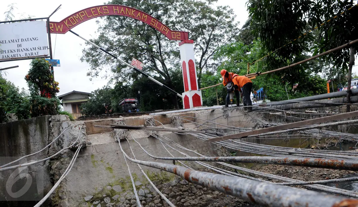 Petugas Suku Dinas Bina Marga Jakarta Barat memperbaiki Jembatan Kali Inspeksi Grogol, Jakarta, (30/5/2016). Pergeseran tanah di bawah Kali Irigasi Grogol sehingga pondasi jembatan bergeser dan permukaan jalan ambles. (Liputan6.com/Helmi Afandi)