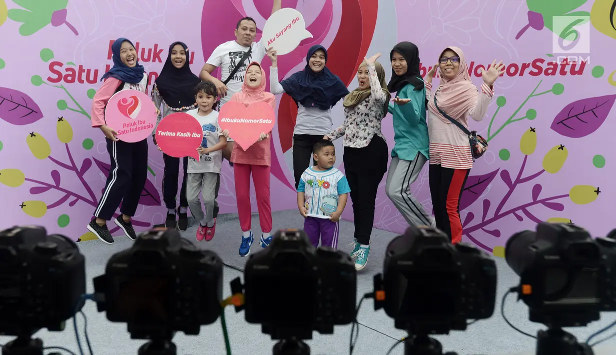 Sejumlah orang berfoto bersama saat acara "Peluk Ibu Satu Indonesia"  selama Car Free Day di Bundaran HI, Jakarta, Minggu (23/12). Acara tersebut memperingati hari ibu dan mengajak masyarakat untuk selalu menghormati ibu. (Merdeka.com/Iqbal S. Nugroho)
