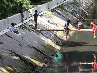 Anak-anak bermain di sungai di Jakarta, Sabtu (7/4). Gubernur DKI Jakarta Anies Baswedan memastikan akan tetap membangun Ruang Terbuka Hijau (RTH). RTH yang dimaksud yakni membangun Taman Maju Bersama dan Taman Pintar. (Liputan6.com/Angga Yuniar)