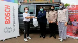Manager Corcomm & Brand Management Bosch Indonesia, Shinta Maryke (kiri) memberikan paket makanan kepada para nakes dan relawan vaksin di Sentra Vaksinasi Polres, Tangerang Selatan (30/9/2021). Sebanyak 1000 paket makanan dibagikan di 18 titik rumah sakit dan sentra vaksinasi. (Liputan6.com/HO/Bon)