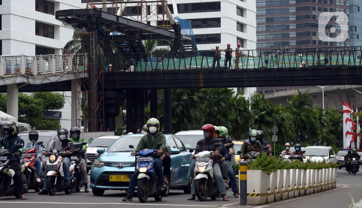 Suasana lalu lintas sekitar proyek Tugu Tenaga Kesehatan di Jembatan Penyeberangan Orang (JPO) Sudirman, Jakarta, Jumat (12/11/2021). Tugu Tenaga Kesehatan dibangun sebagai monumen perjuangan dan pengorbanan tenaga medis dalam menangani COVID-19. (merdeka.com/Imam Buhori)