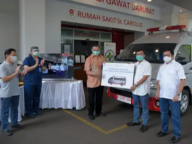 Chief Astra Financial Adi Sepiarso secara simbolis menyerahkan satu unit mobil Ambulance Gawat Darurat kepada Dirut RS St Carolus, Rudyan Kopot (tengah) di Rumah Sakit St Carolus, Jakarta, Rabu (8/4/2020). Selian mobil ambulance juga diserahkan peralatan medis. (Liputan6.com/HO/Eko)