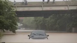 Sebuah mobil terjebak banjir di Sao Paulo, Brasil, Senin, (10/2/2020). Hujan deras yang membanjiri kota, menyebabkan pinggir sungai utama meluap. (AP Photo/Andre Penner)