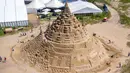 Pemahat beraktivitas di istana pasir tertinggi pada kompetisi tahunan "Sand Sculptures Festival" di Binz, Pulau Reugen di Laut Baltik, Jerman, 5 Juni 2019. Kompetisi sandcastle ini sendiri telah menjadi agenda tahunan pada kalender sosial Binz sejak tahun 2010. ( Jens Buettner/dpa via AP)