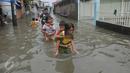 Sejumlah anak menggendong adiknya melewati banjir di Rawa Buaya, Jakarta, Minggu (28/2/2016). Banjir akibat luapan Kali Mookervart ini menyebabkan ratusan rumah warga tergenang air rata-rata satu meter. (Liputan6.com/Gempur M Surya)