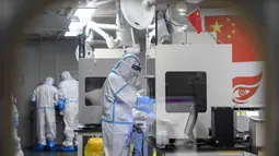 Teknisi laboratorium yang mengenakan alat pelindung diri (APD) mengerjakan sampel yang akan diuji untuk virus corona Covid-19 di laboratorium Fire Eye, fasilitas pengujian Covid-19, di Wuhan di provinsi Hubei tengah China (5/8/2021). (AFP/STR)