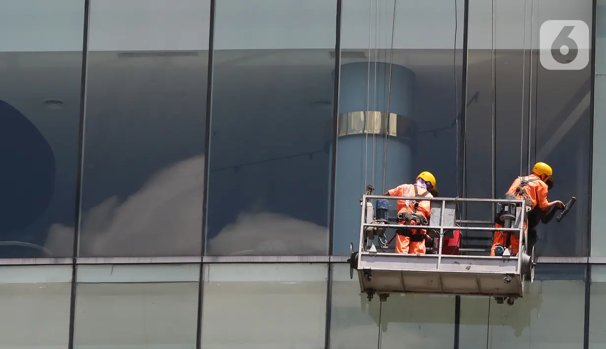 Pekerja membersihkan kaca gedung bertingkat di kawasan Jakarta, Kamis (2/4/2020). Dari 128 juta angkatan kerja di Indonesia, hanya 39% atau 50 jutaan pekerja yang terlindungi jaminan sosial ketenagakerjaan. (Liputan6.com/Herman Zakharia)