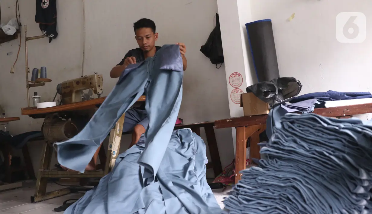 Pekerja menyelesaikan pembuatan seragam sekolah di usaha konveksi skala rumah tangga Kebayoran Lama, Jakarta, Kamis (9/7/2020). Pandemi virus corona COVID-19 berdampak pada sepinya pesanan pembuatan seragam sekolah. (Liputan6.com/Angga Yuniar)