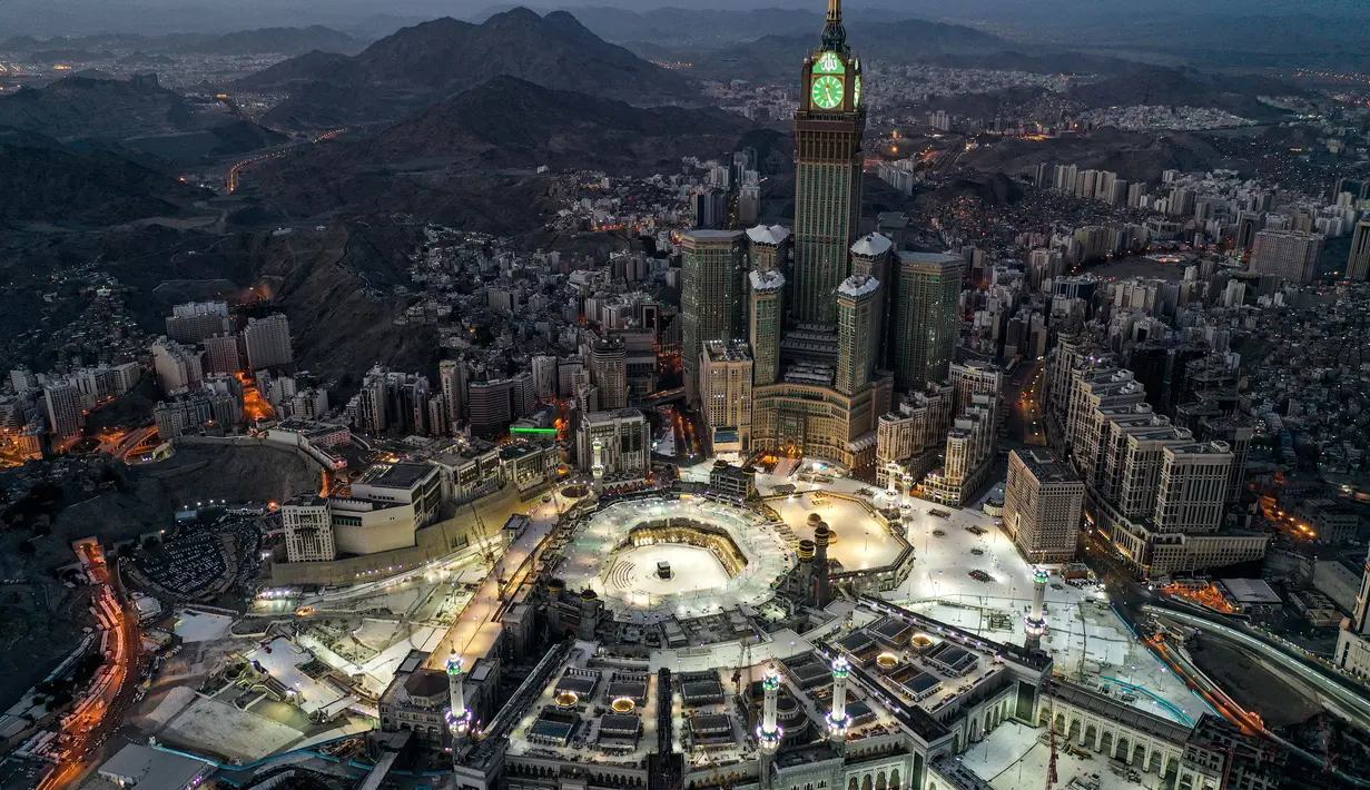 Gambar yang diambil pada 24 Mei 2020 selama jam-jam awal Hari Raya Idul Fitri menunjukkan pandangan udara kota suci Mekkah Arab Saudi dengan Makkah Royal Clock Tower menghadap Masjidil Haram dan Ka'bah.  (Photo by - / AFP)