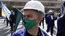Penambang batubara memegang bendera Bosnia dan berbaris selama unjuk rasa May Day pada Hari Buruh Internasional di Sarajevo, pada Sabtu (1/5/2021).. Beberapa ratusan penambang batubara Bosnia memprotes menuntut upah dan kondisi kerja yang lebih baik. (AP Photo/Eldar Emric)