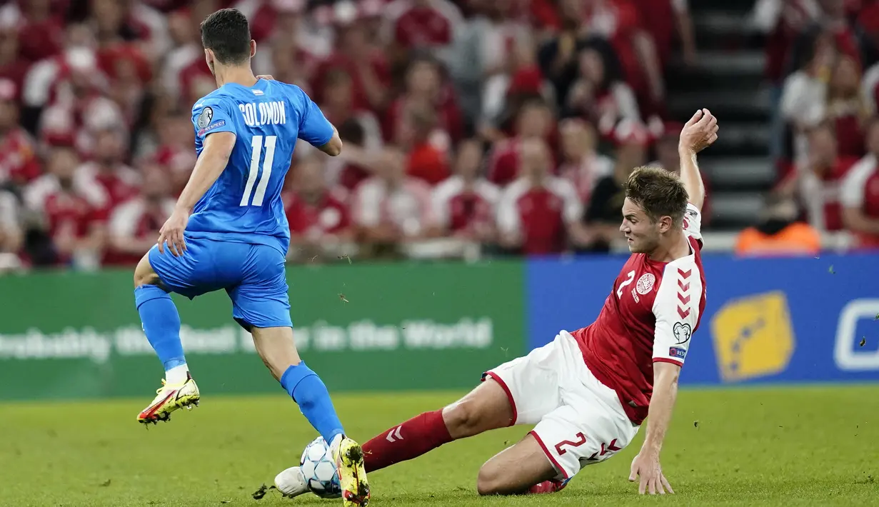 Pemain depan Israel, Manor Solomon berusaha melewati bek Denmark, Joachim Andersen selama pertandingan kualifikasi Grup F Piala Dunia FIFA Qatar 2022 di Kopenhagen (7/9/2021). Denmark menang telak ats Israel dengan skor 5-0. (Mads Claus Rasmussen/Ritzau Scanpix/AFP)