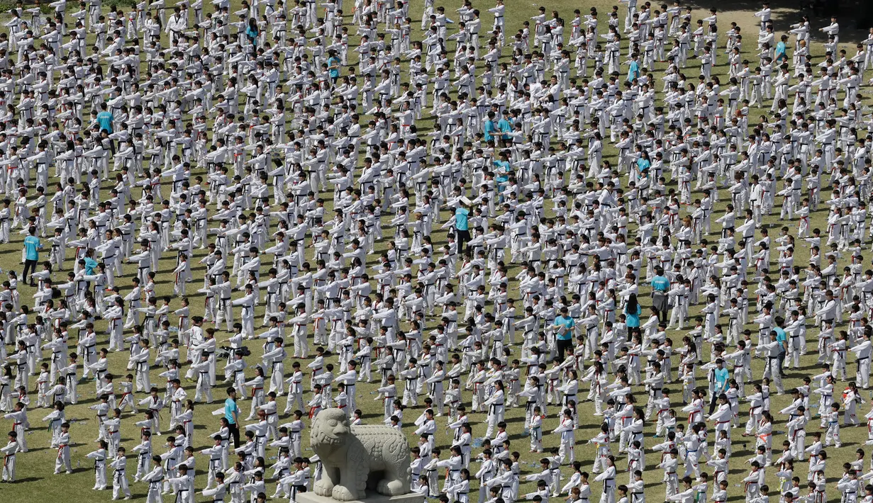 Peserta memperagakan seni bela diri taekwondo di depan Gedung Majelis Nasional Korea Selatan, Seoul, 21 April 2018. Peserta adalah para atlet taekwondo profesional, prajurit angkatan darat, laut, udara dan kepolisian serta kalangan sipil. (AP/Lee Jin-man)