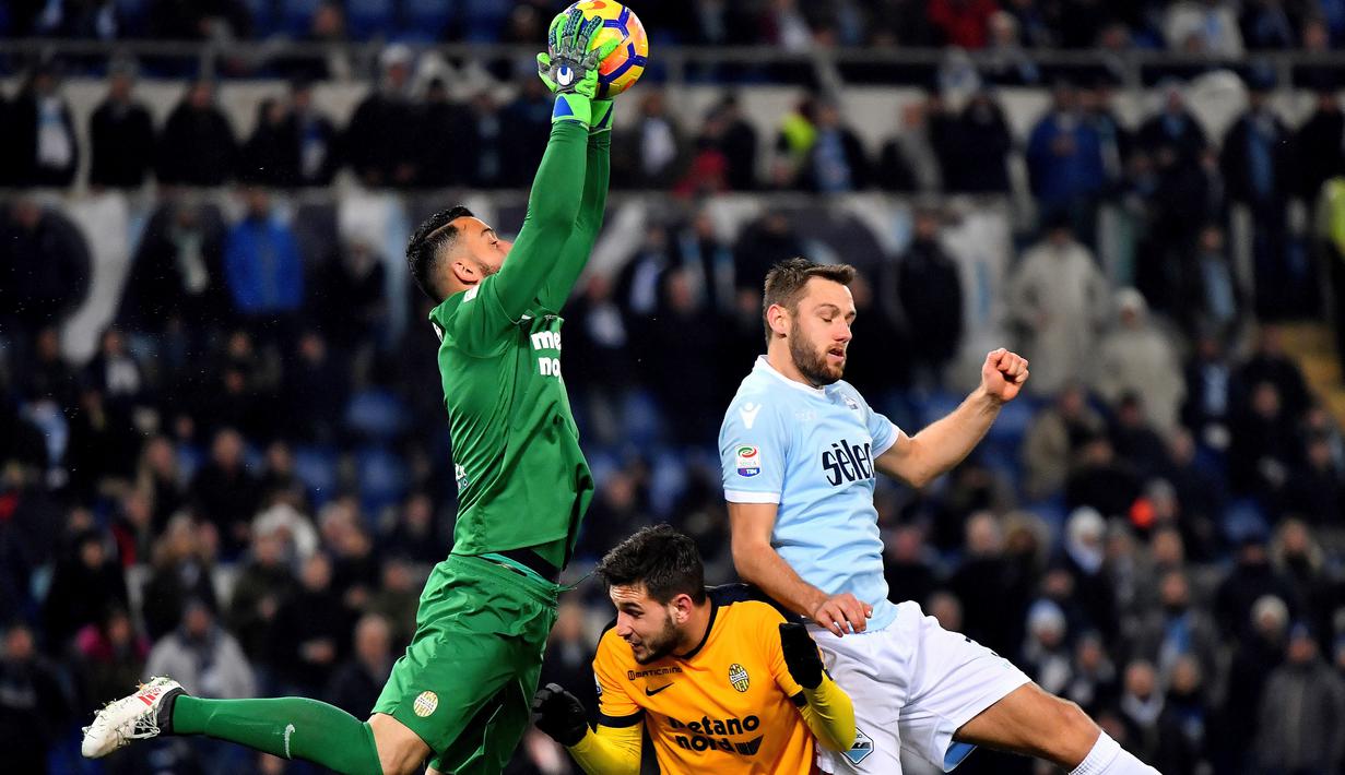 Kiper Hellas Verona, Nicolas Andrade (kiri) mengamankan bola dari kejaran pemain Lazio, Stefan de Vrij (kanan) pada lanjutan Serie A di di Olympic stadium, Roma, (19/2/2018). Lazio menang 2-0. (AFP/Alberto Pizzoli)
