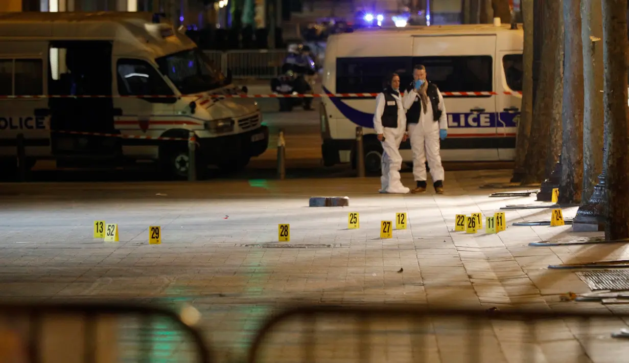 Ahli forensik melakukan penyelidikan di lokasi penembakan terhadap tiga aparat kepolisian Prancis di kawasan Champs Elysees, Paris, Kamis (20/4). Seorang polisi tewas dan dua lainnya terluka dalam insiden penembakan tersebut. (AP Photo/Kamil Zihnioglu)